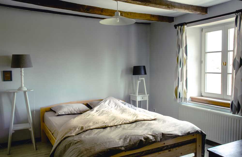 Un lit double et une fenêtre qui ouvre sur le jardin