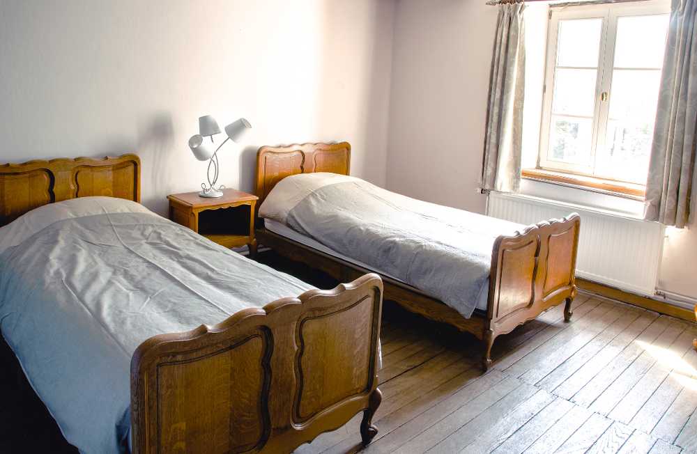 Deux lits simples et une grande fenêtre