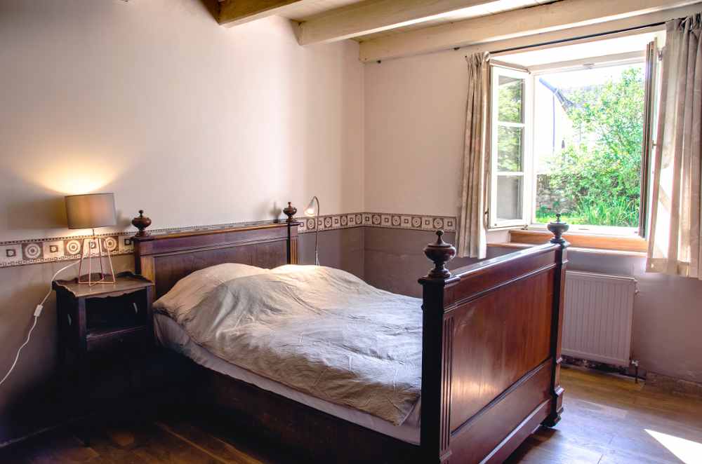 Un lit de 120 cm et une grande fenêtre qui ouvre sur le jardin de la cour